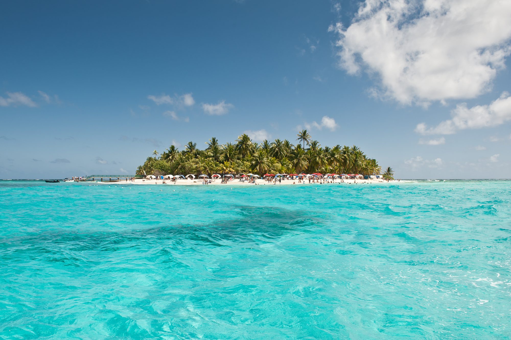 Johnny Cay, em San Andrés, com mar azul-turquesa e coqueiros