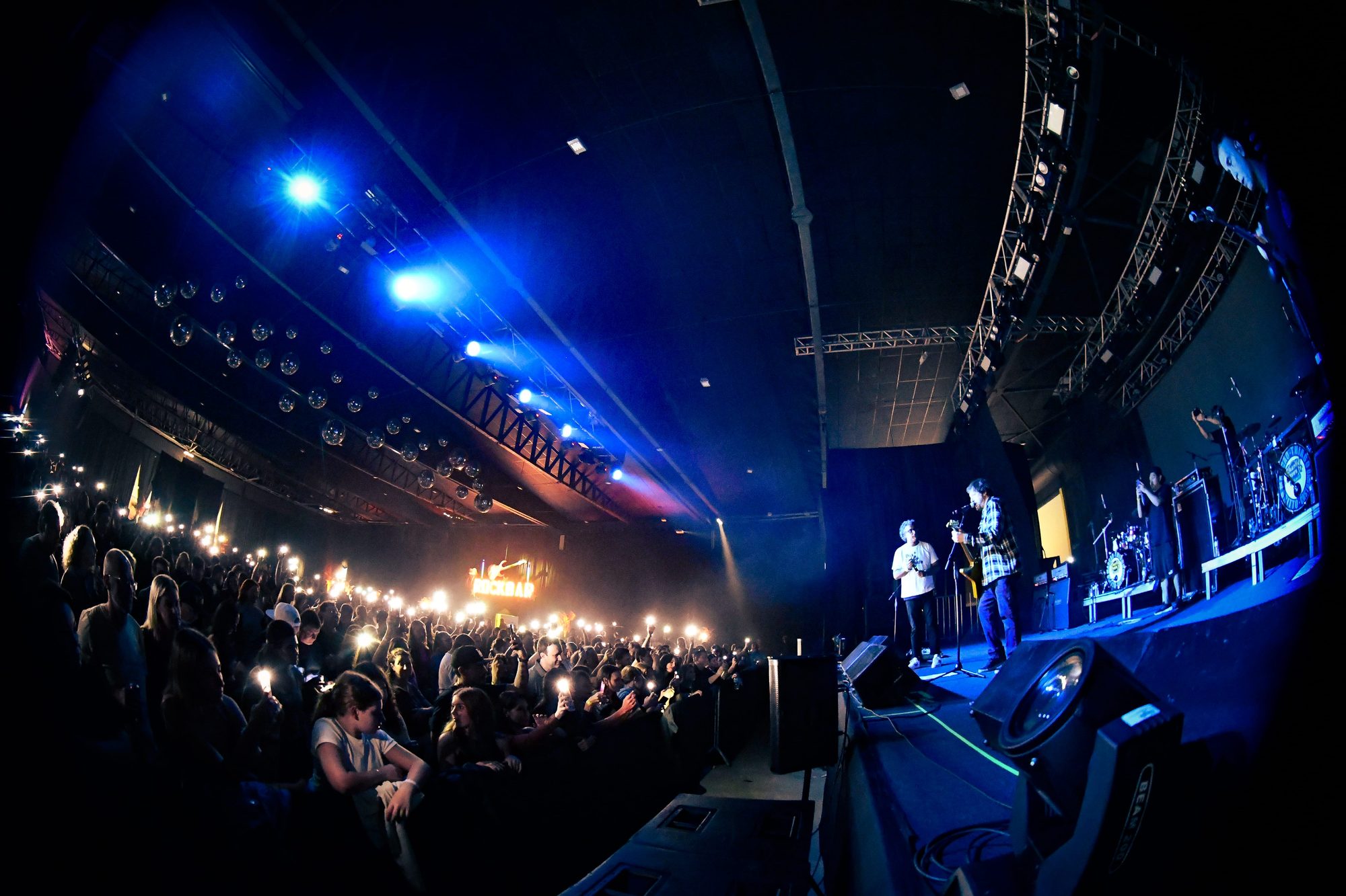 Banda no palco e plateia com luzes durante o Rock Weekend