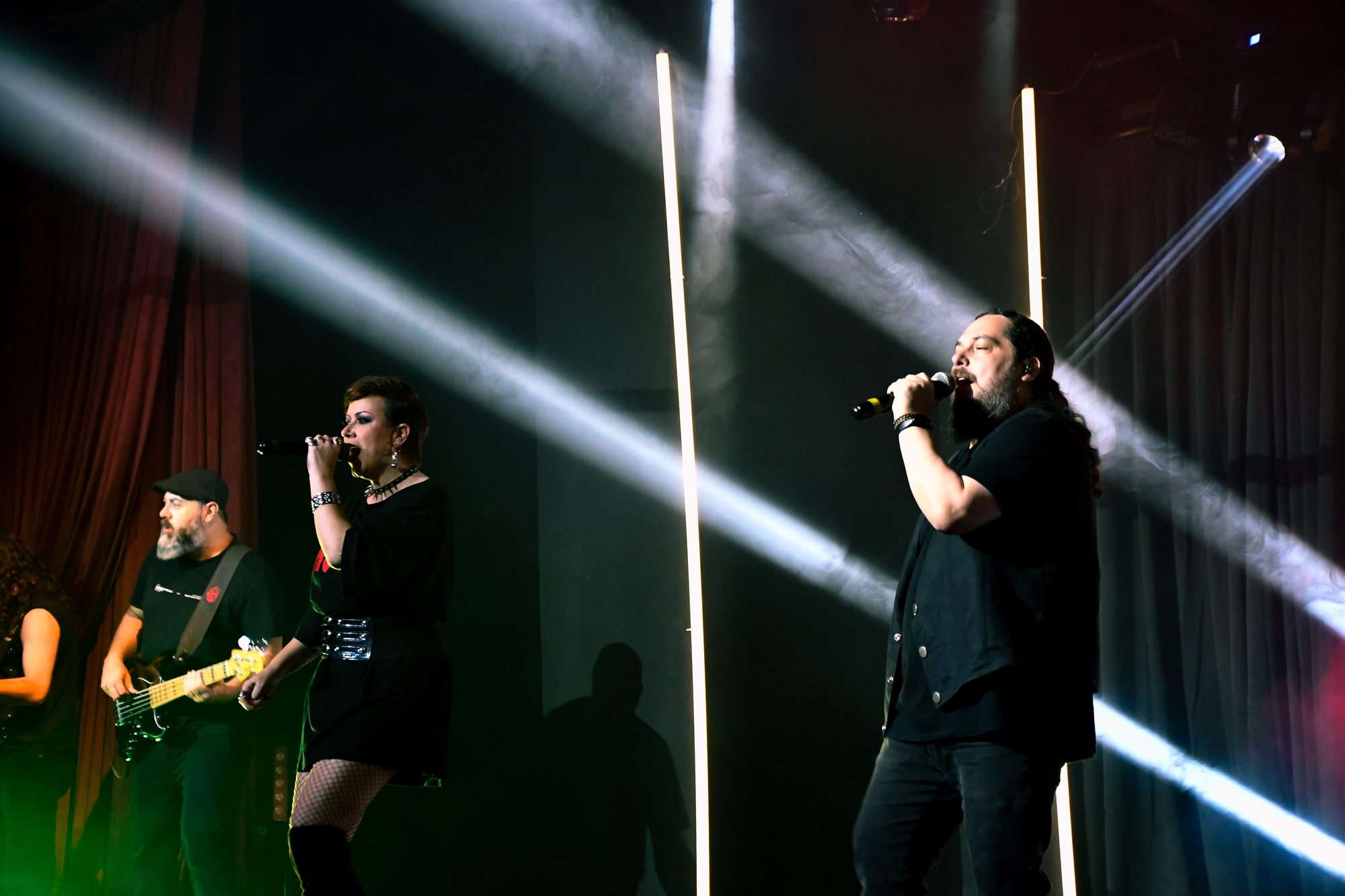 Vocalistas cantando sob a luz dos refletores no Rock Weekend